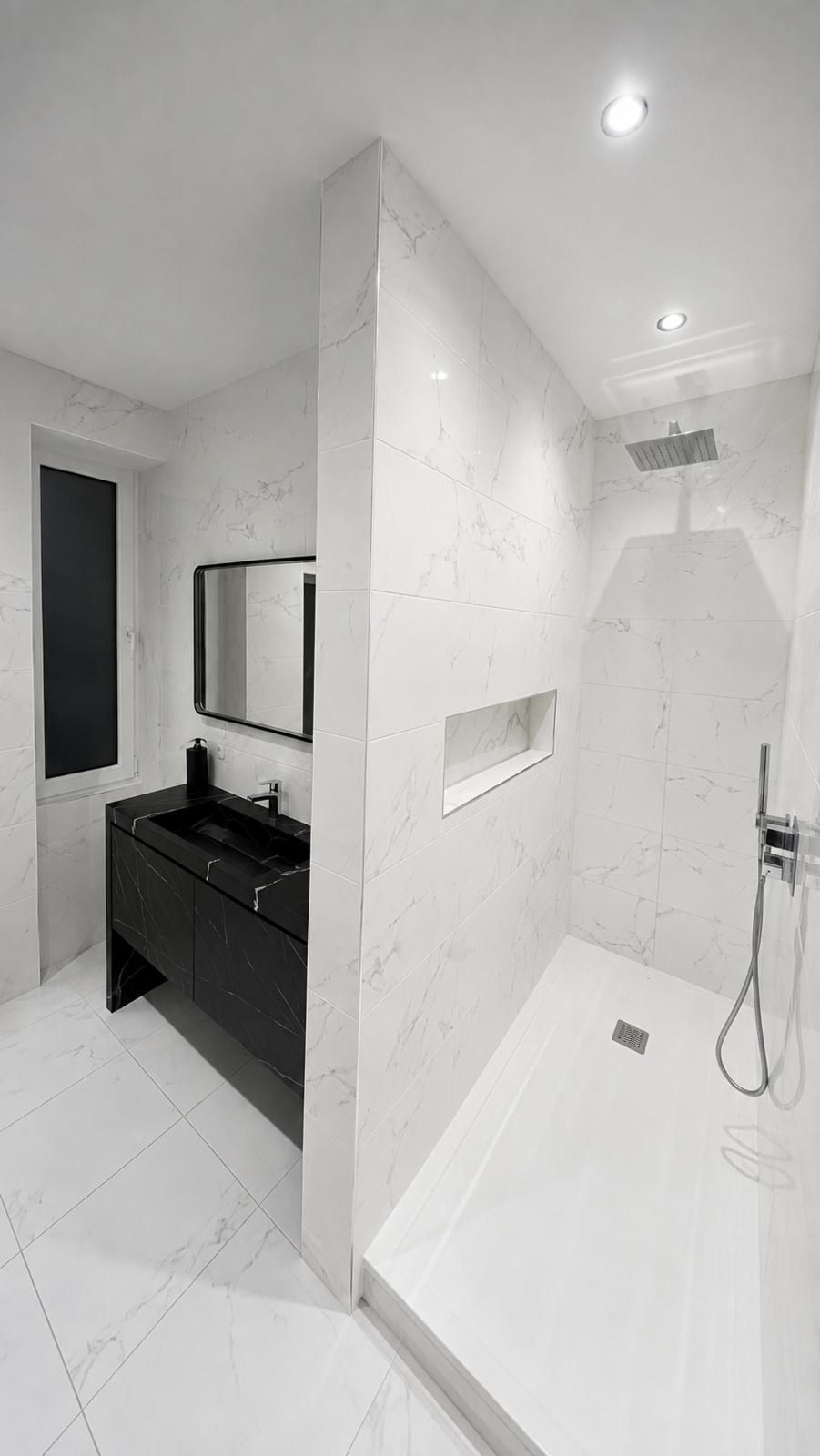 Salle de bain réalisée par ENP, douche à l’italienne en marbre blanc et meuble vasque noir